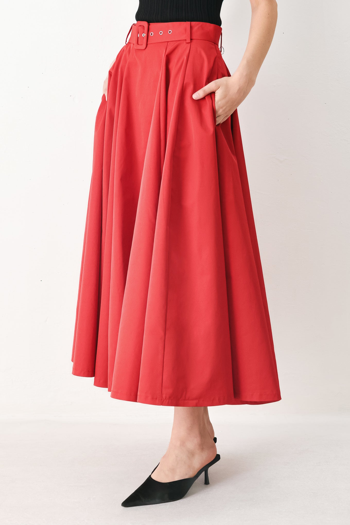 Woman wearing a red full midi skirt featuring self belt and side zipper closure | FREEMARKET