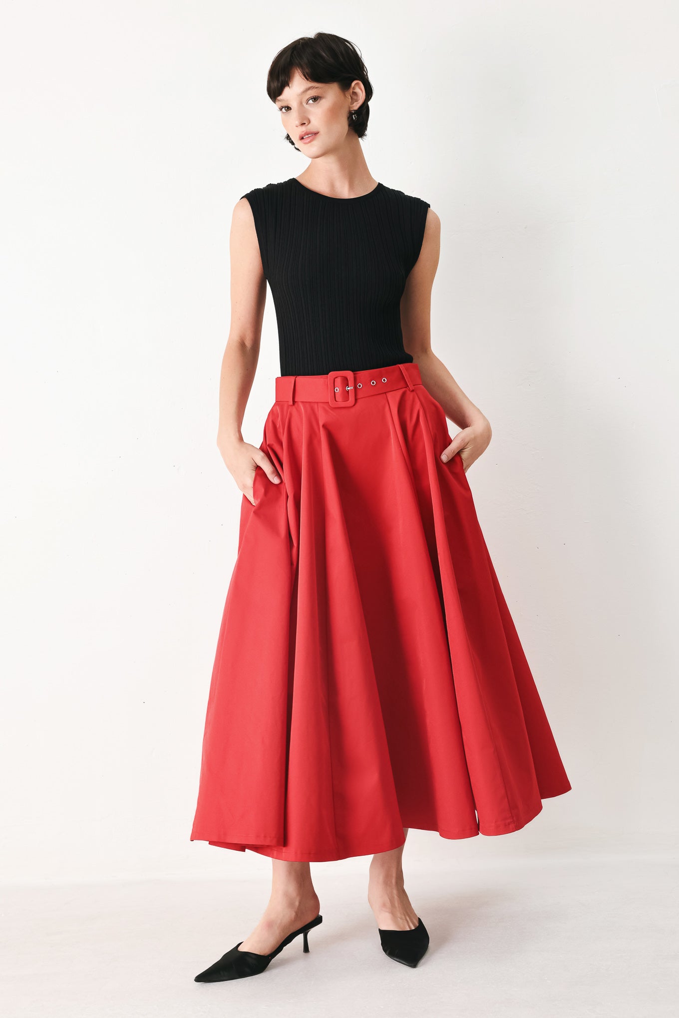 Woman wearing a red full midi skirt featuring self belt and side zipper closure | FREEMARKET