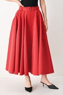 Woman wearing a red full midi skirt featuring self belt and side zipper closure | FREEMARKET