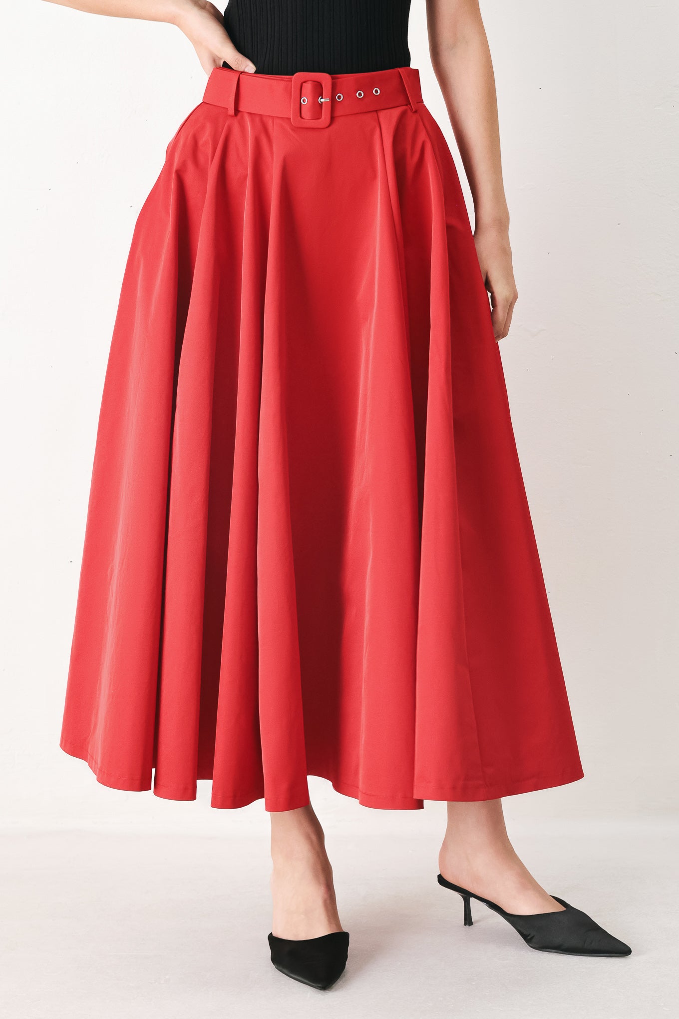 Woman wearing a red full midi skirt featuring self belt and side zipper closure | FREEMARKET
