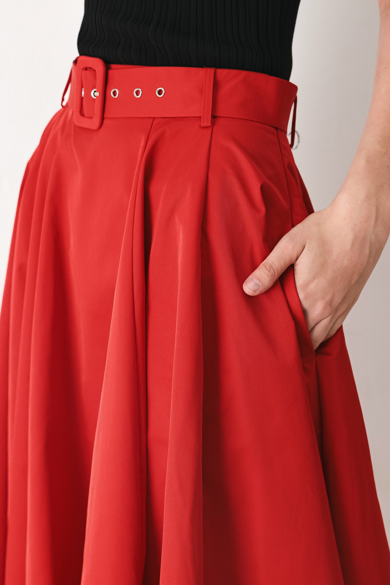 Woman wearing a red full midi skirt featuring self belt and side zipper closure | FREEMARKET