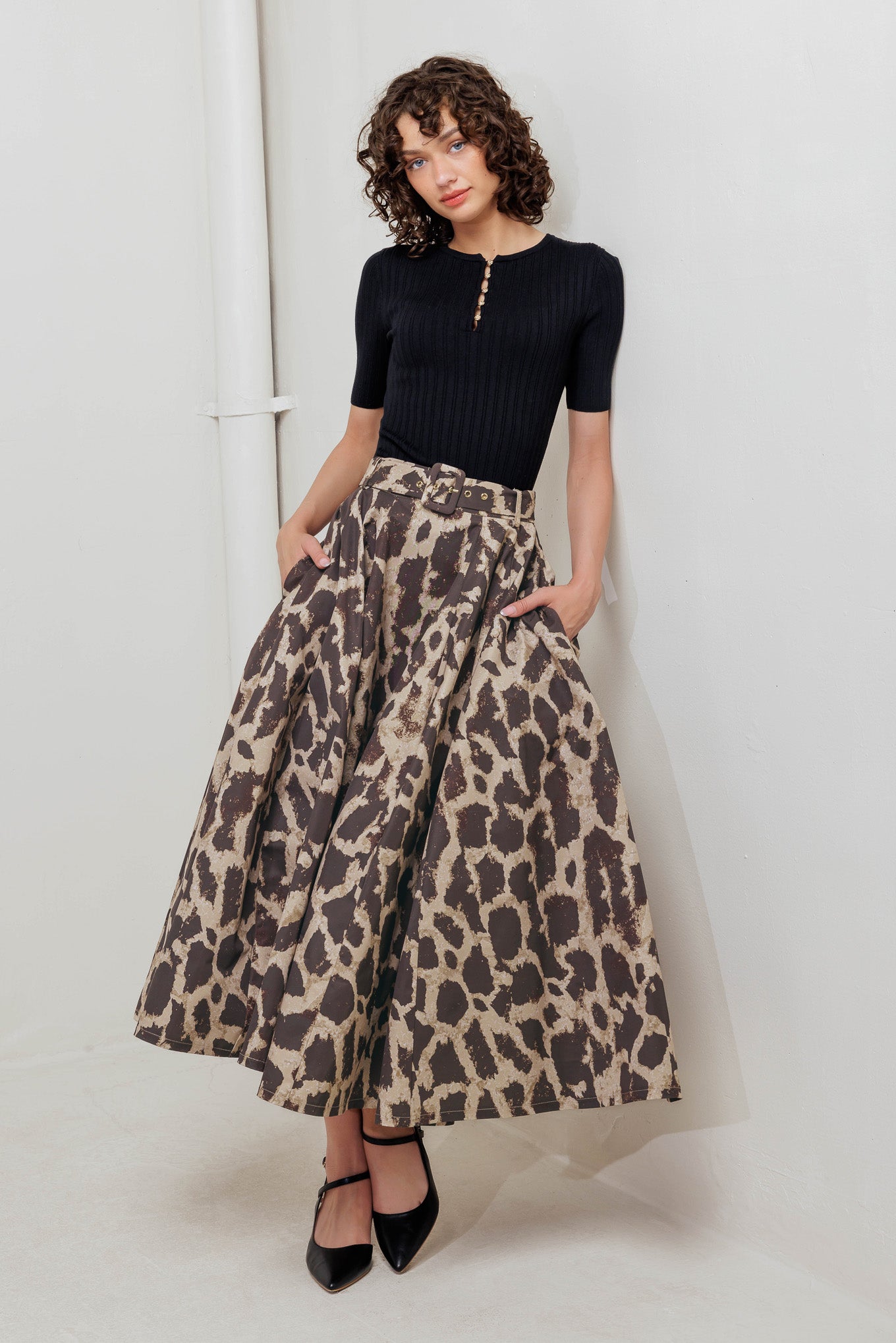 A printed woven full midi skirt featuring self belt, side pockets and zipper closure