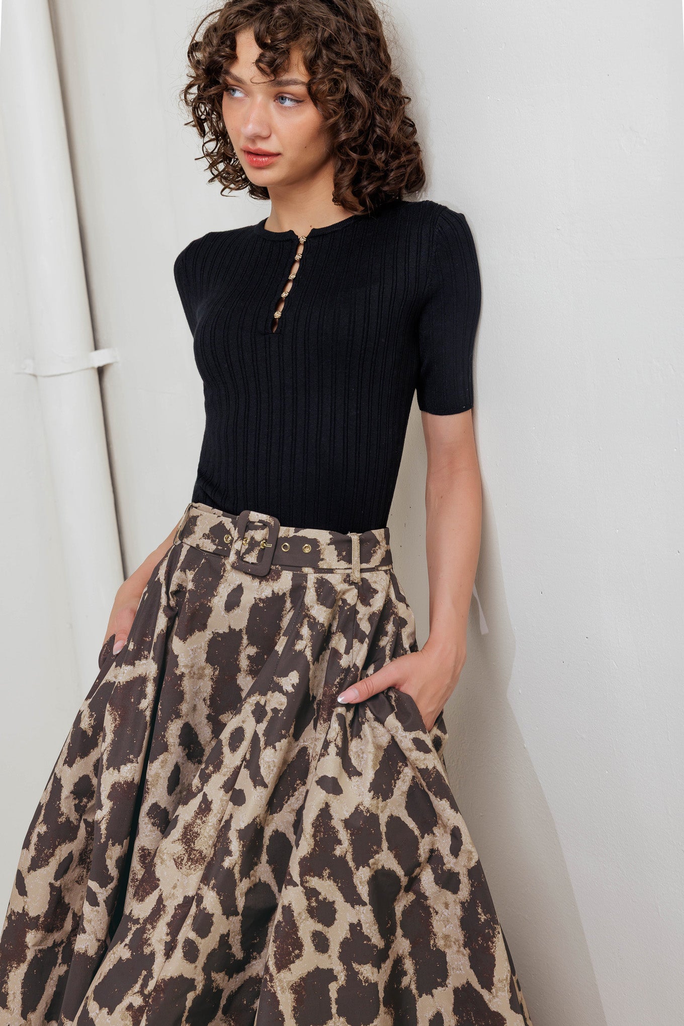 A printed woven full midi skirt featuring self belt, side pockets and zipper closure