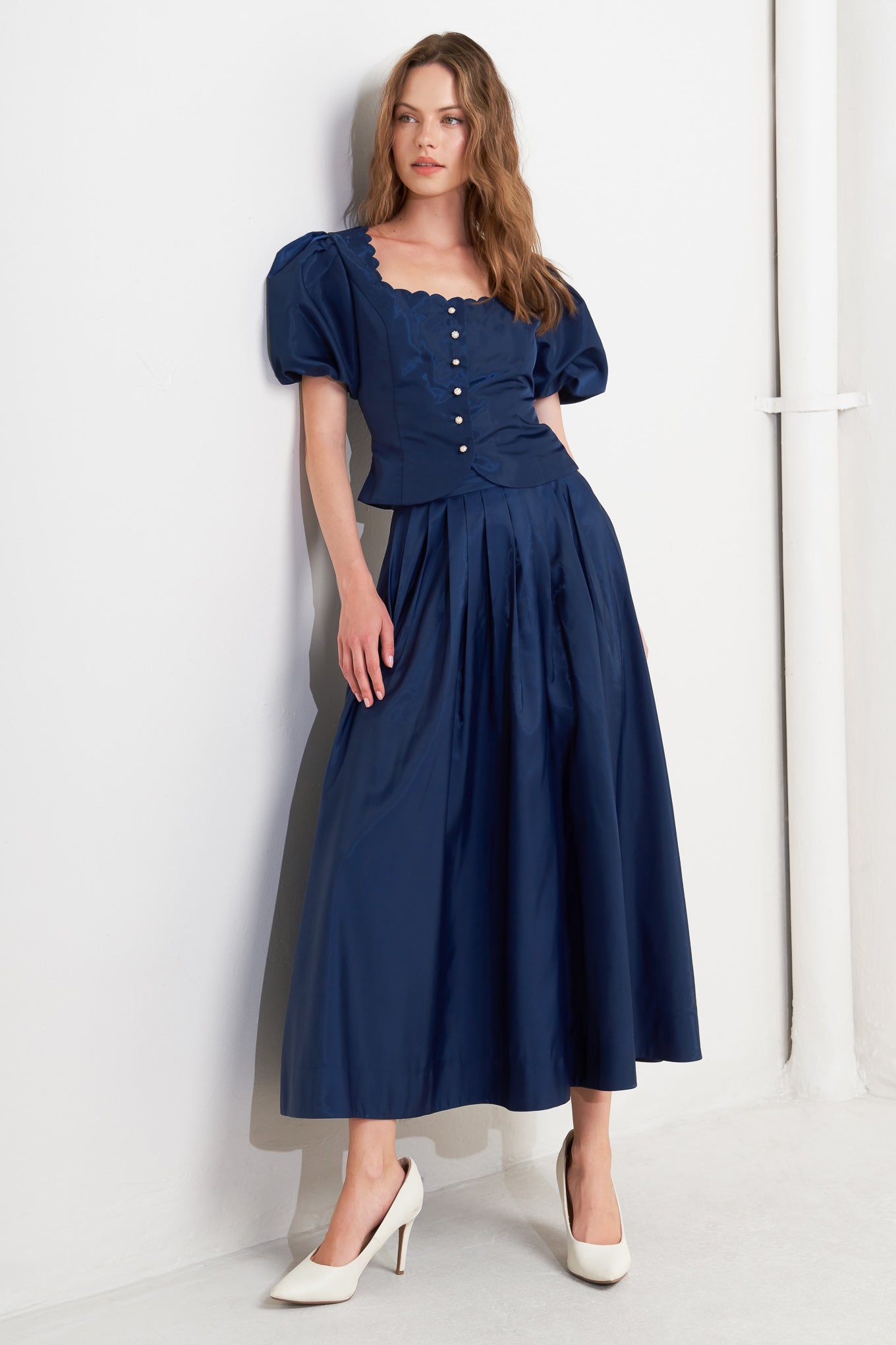 A solid navy woven pleated midi skirt with back zipper.
