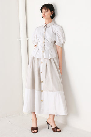 Woman wearing a taupe and white striped woven midi skirt with front button detail, box pleats and back zipper closure | FREEMARKET