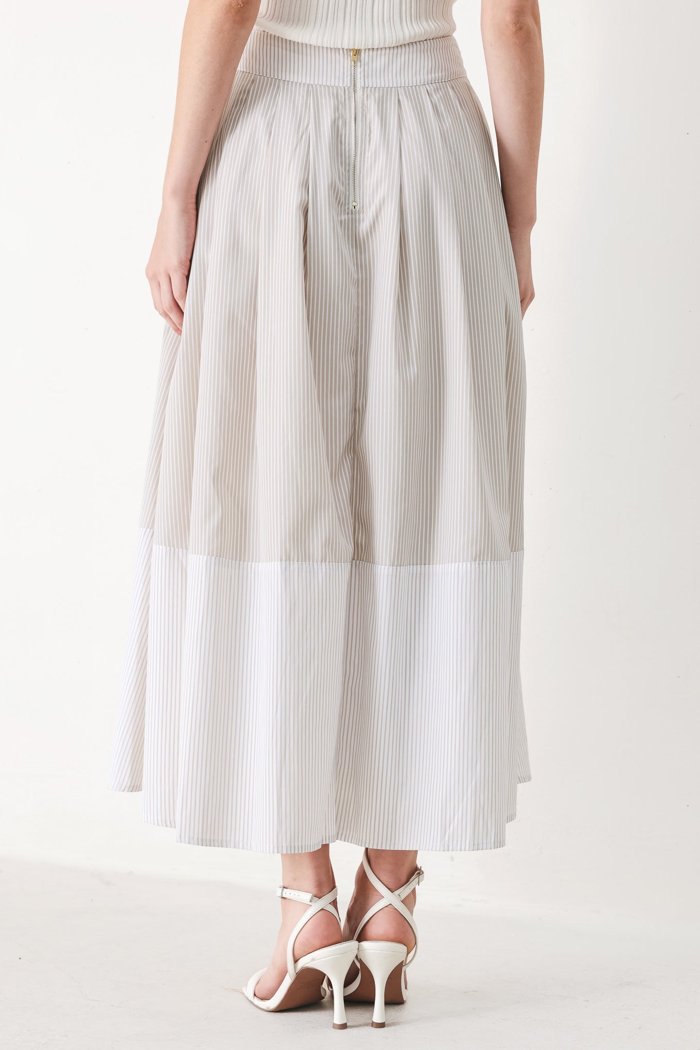 Woman wearing a taupe and white striped woven midi skirt with front button detail, box pleats and back zipper closure | FREEMARKET