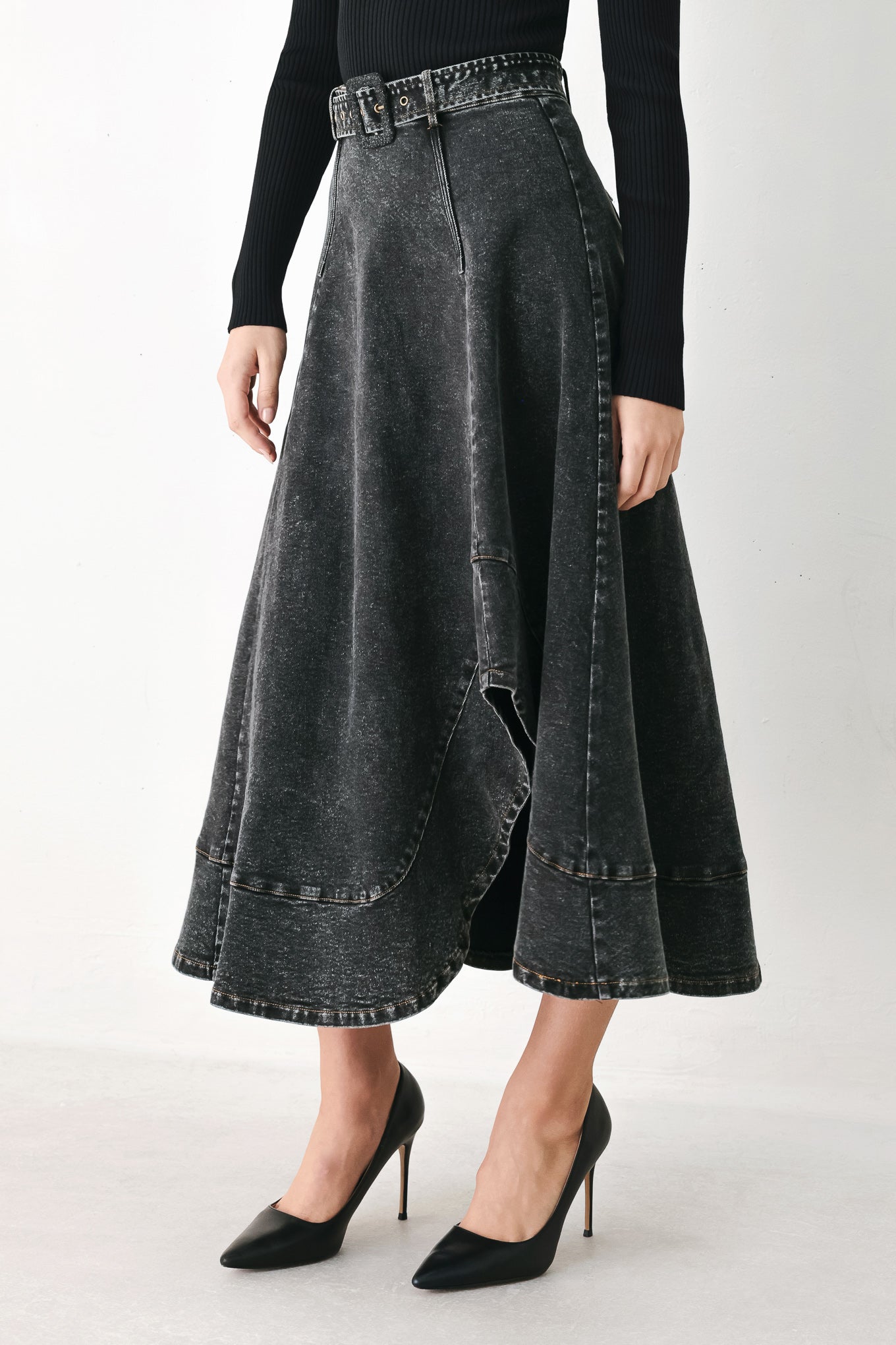A model wearing a high-waisted, dark gray washed denim midi skirt with a decorative studded belt | FREEMARKET