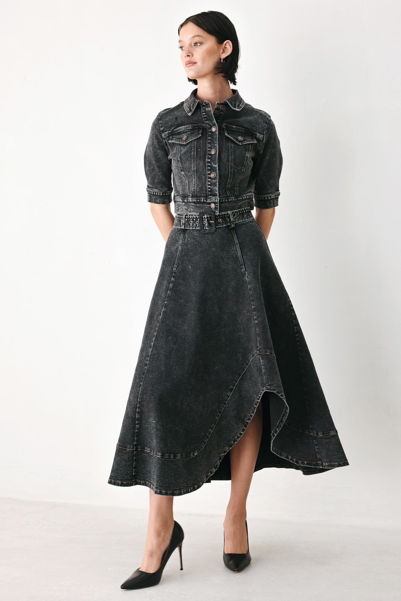 A model wearing a high-waisted, dark gray washed denim midi skirt with a decorative studded belt | FREEMARKET