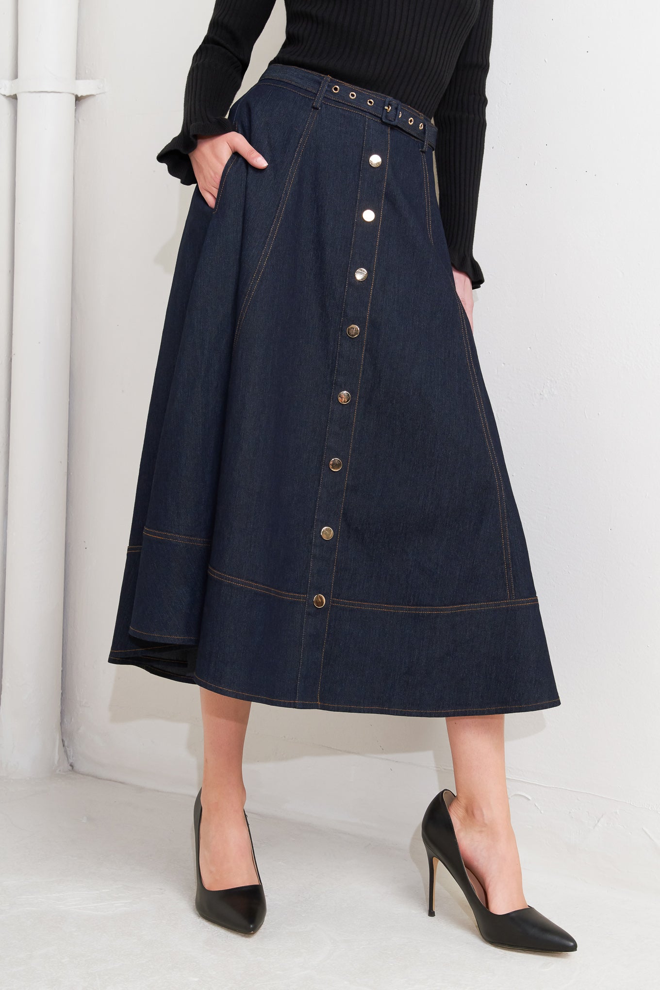 A denim circle skirt featuring self belt, front button down and wide hemline