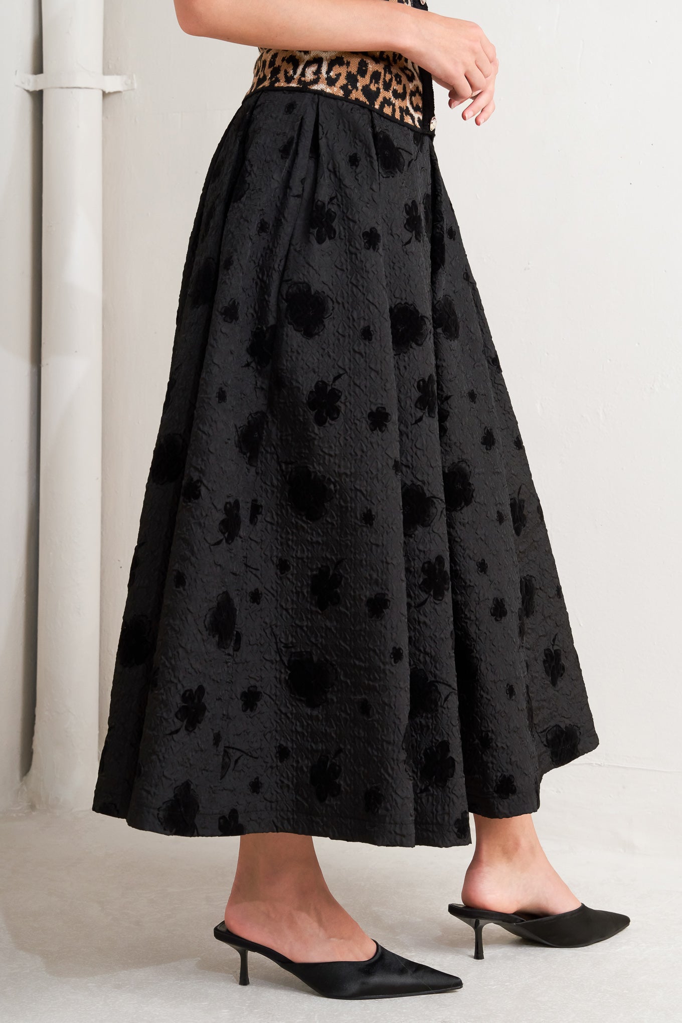 A textured woven full midi skirt with self belt and back zipper closure.