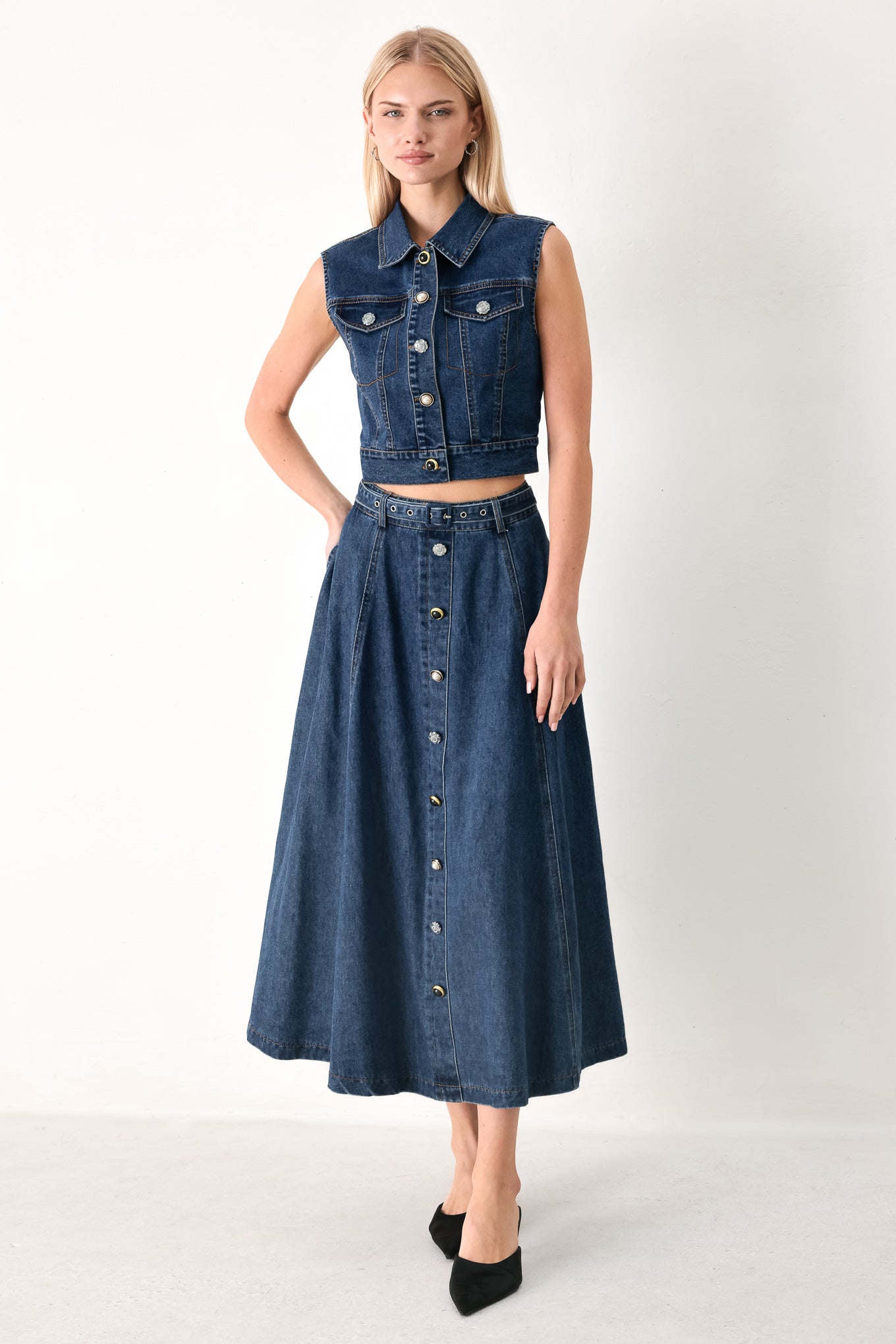 Woman wearing a blue denim circle midi skirt featuring self belt, button down detail and back zipper closure | FREEMARKET