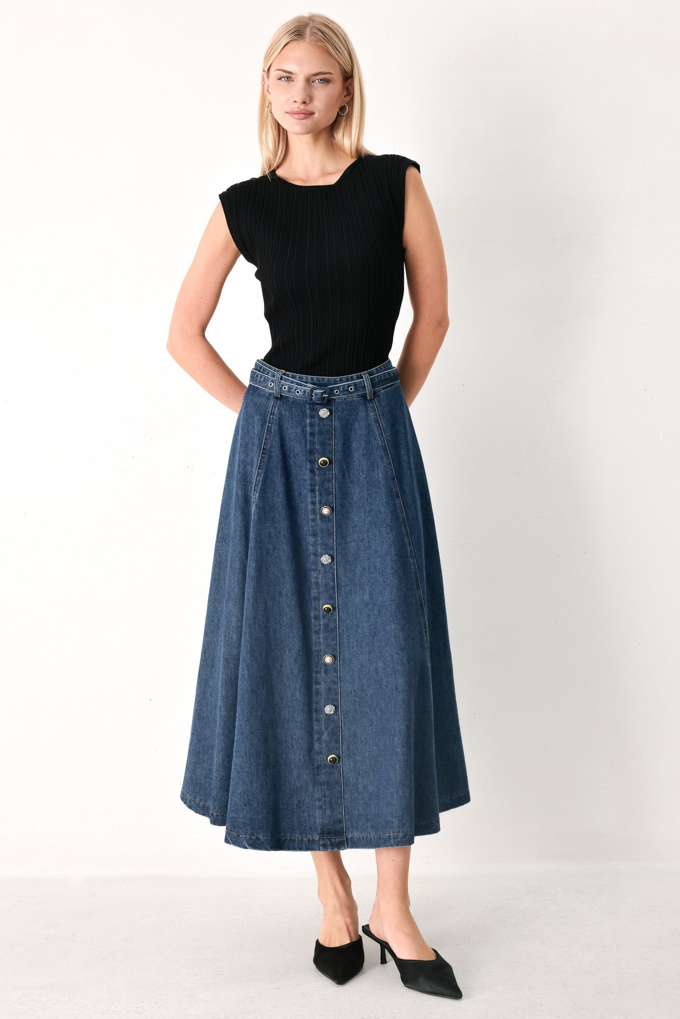 Woman wearing a blue denim circle midi skirt featuring self belt, button down detail and back zipper closure | FREEMARKET