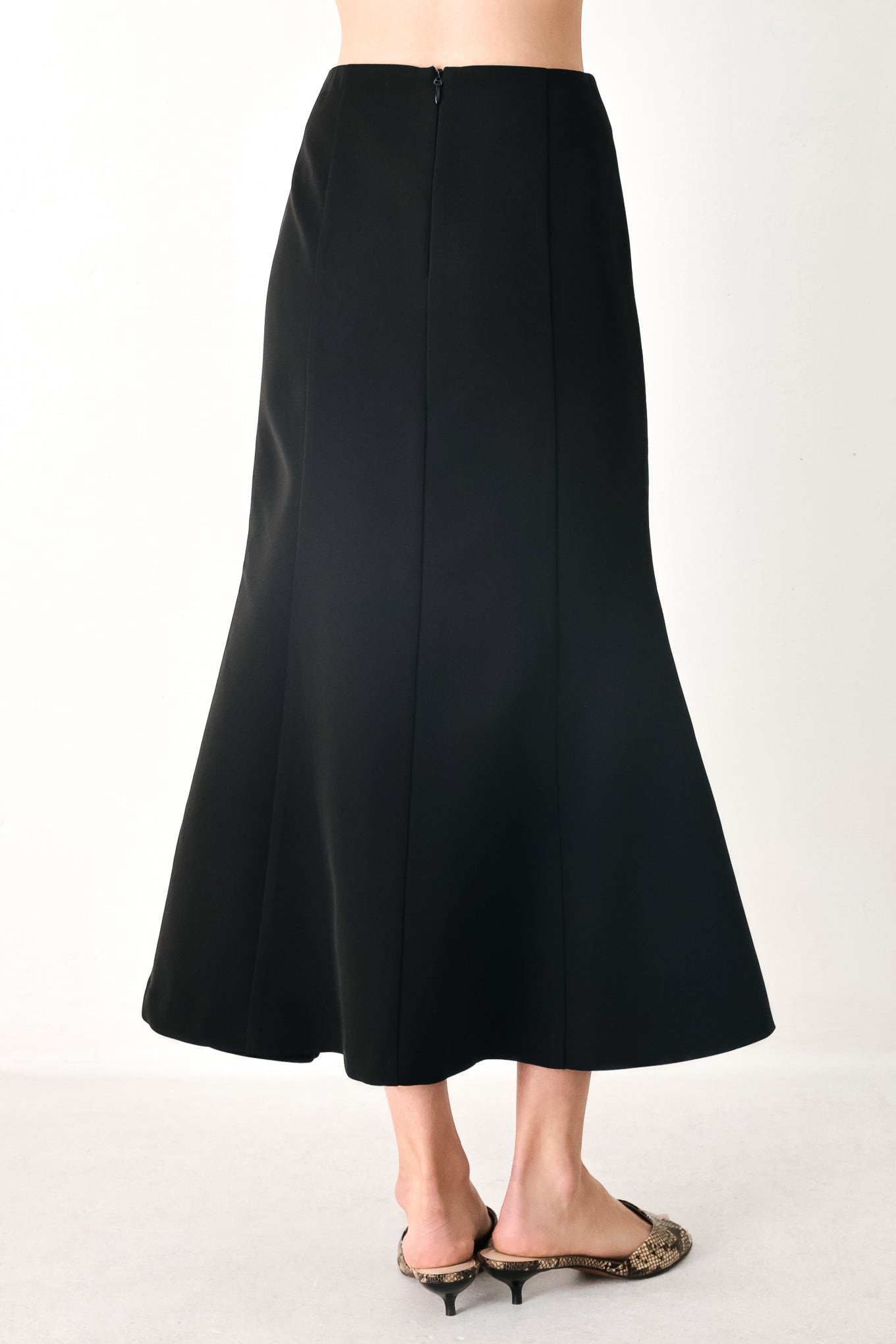Woman wearing a black midi skirt with back zipper closure | FREEMARKET