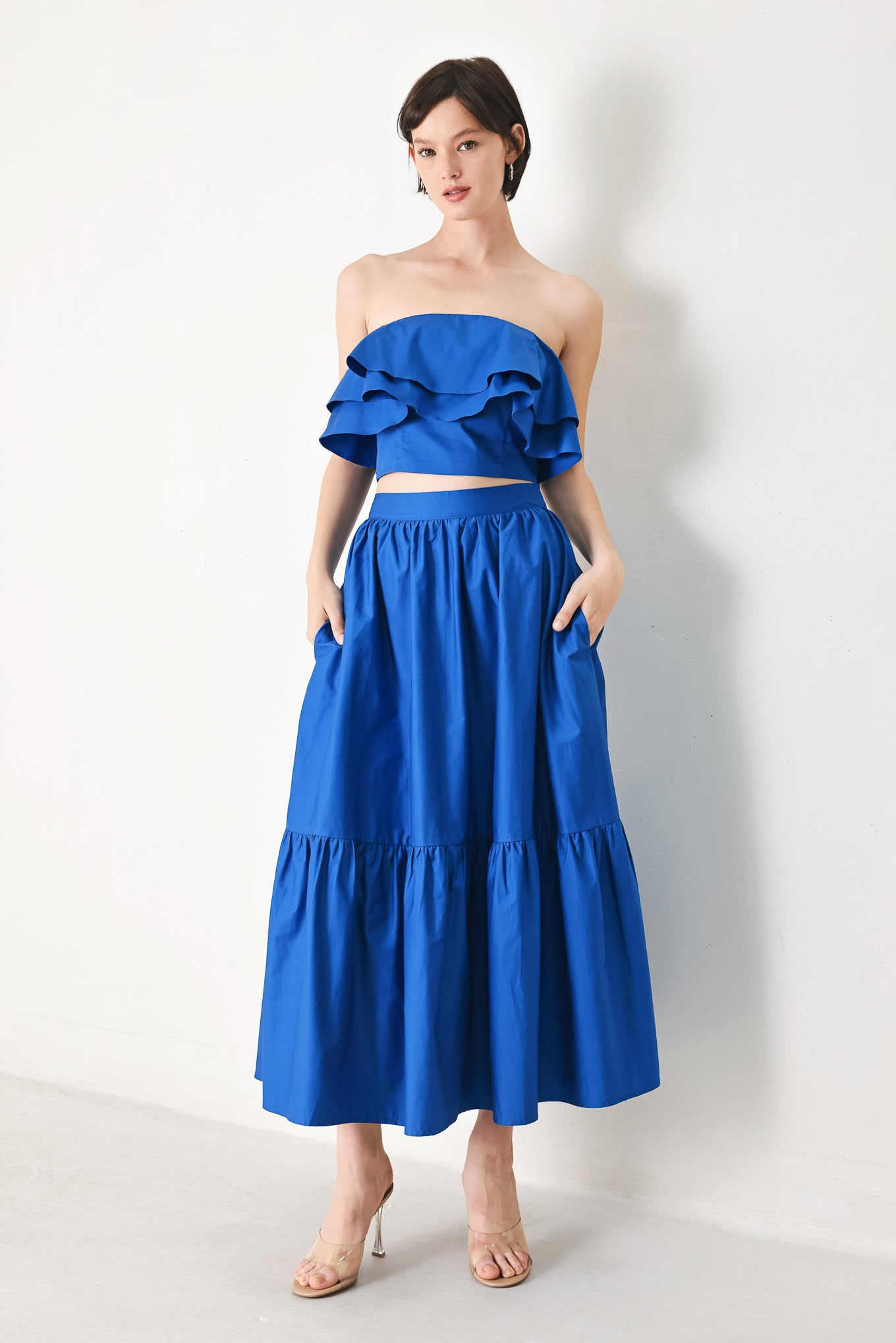 A solid woven midi skirt with ruffle hem and back zipper closure.