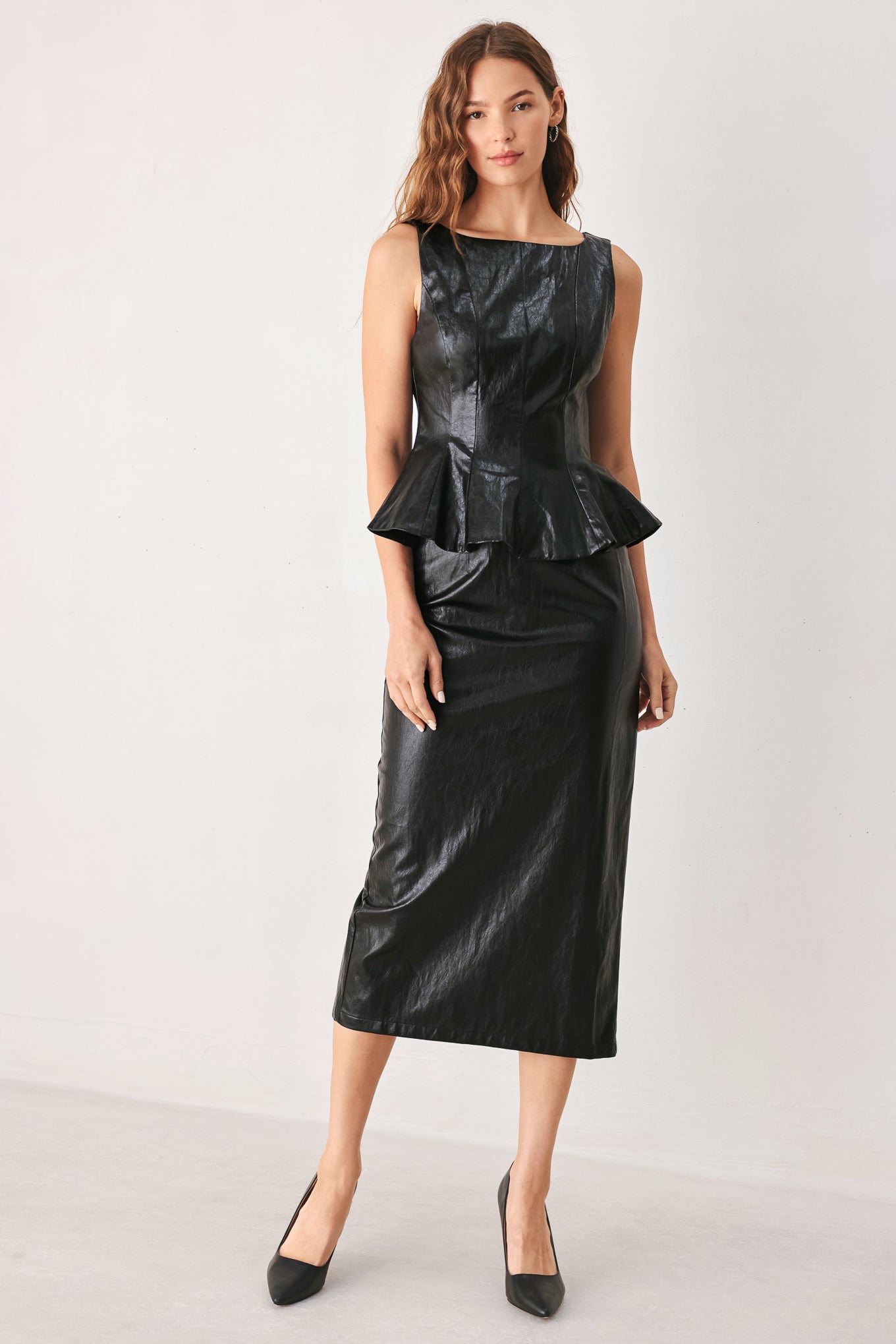 A woman wearing a black faux-leather midi skirt | FREEMAKRET