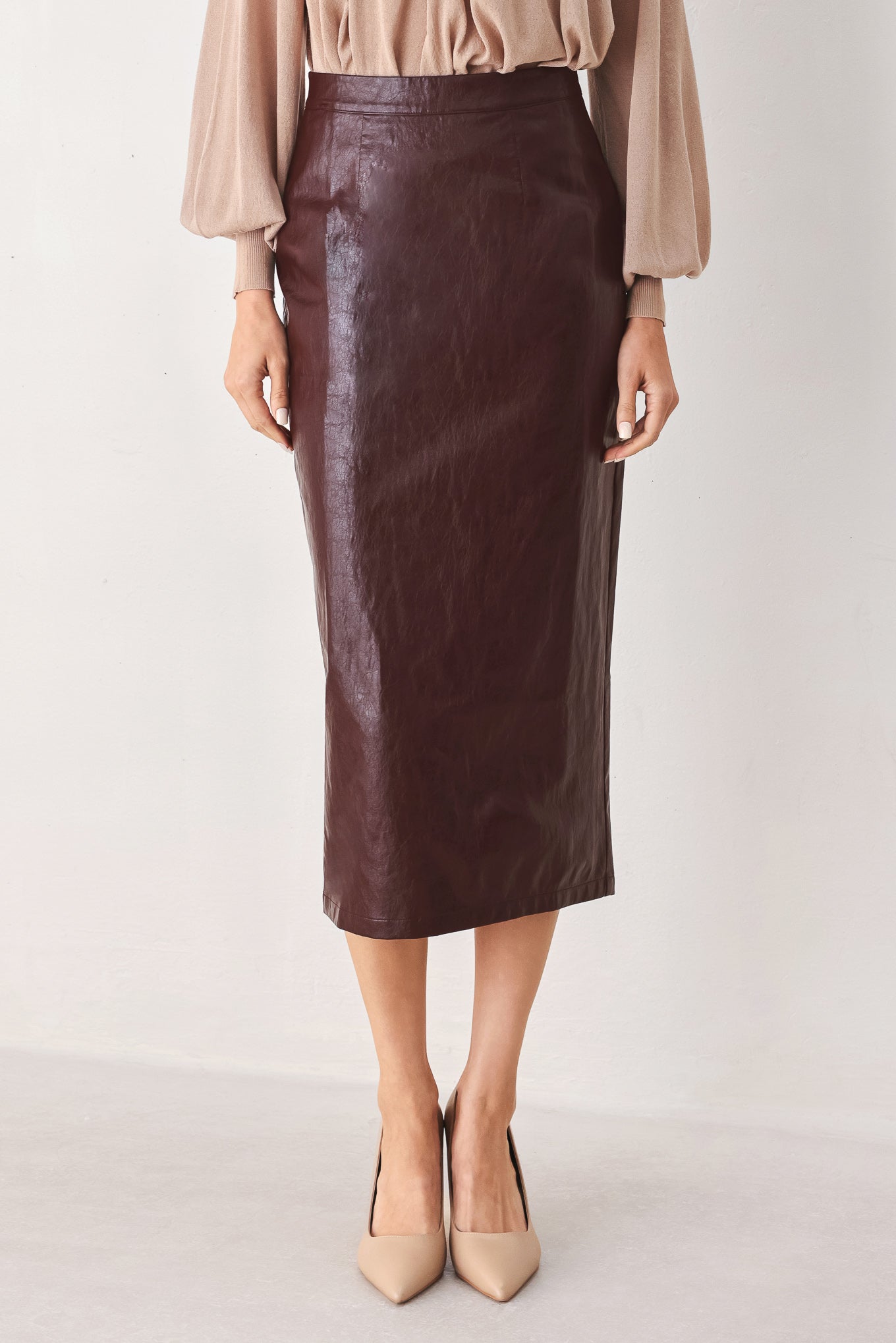 A woman wearing a burgundy faux-leather midi skirt | FREEMAKRET