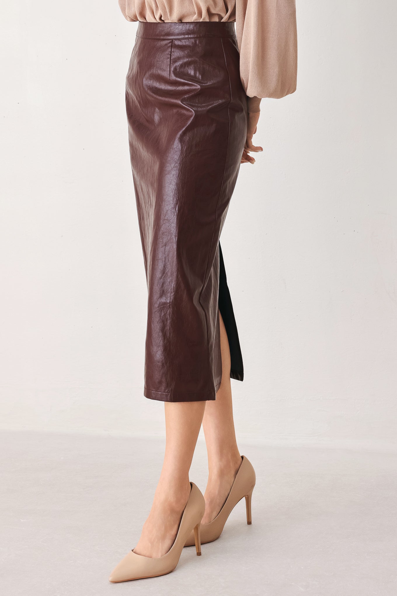 A woman wearing a burgundy faux-leather midi skirt | FREEMAKRET