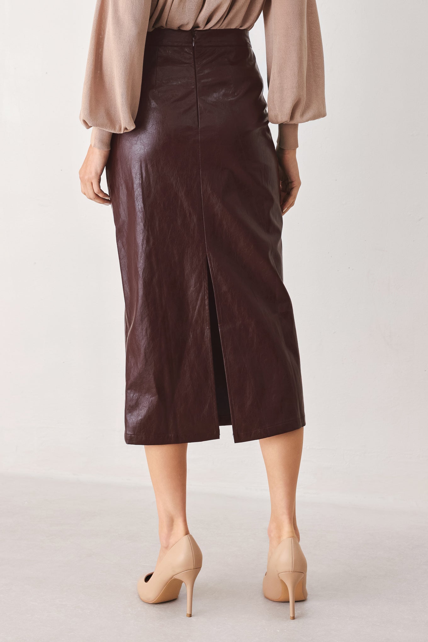 A woman wearing a burgundy faux-leather midi skirt | FREEMAKRET