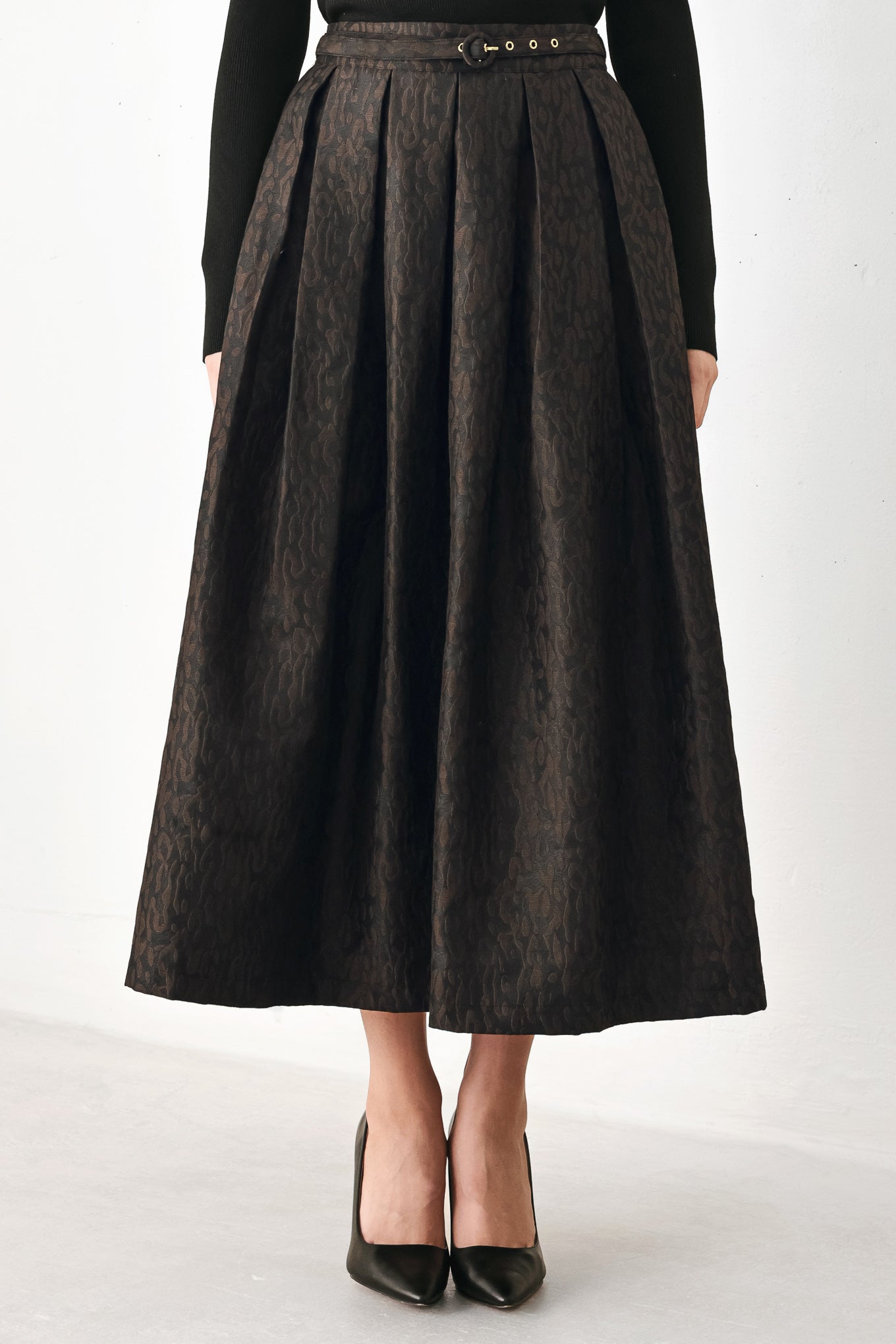 A high-waisted, pleated midi skirt in a dark brown and black jacquard leopard print pattern, styled with a matching belt  | FREEMARKET