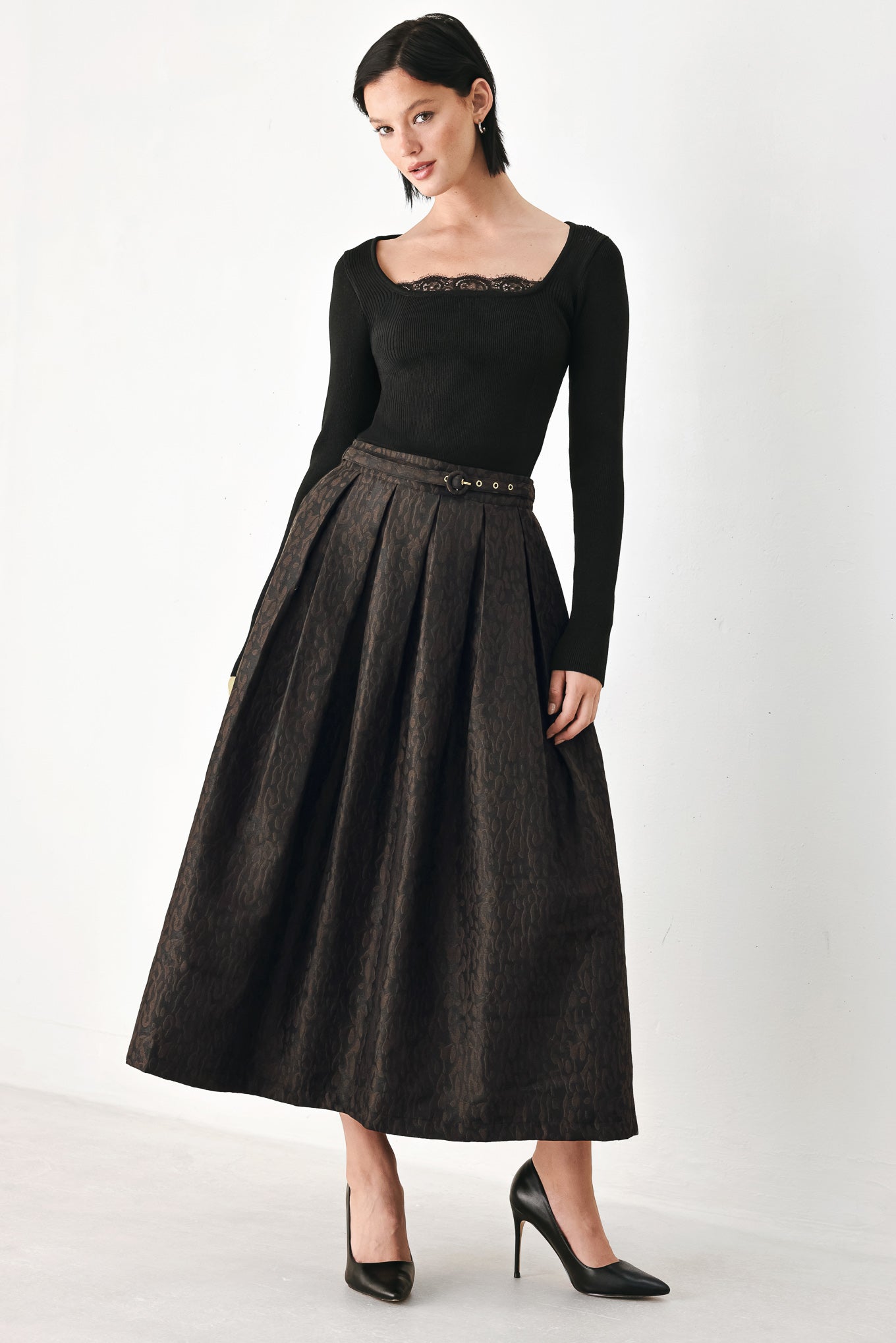 A high-waisted, pleated midi skirt in a dark brown and black jacquard leopard print pattern, styled with a matching belt  | FREEMARKET