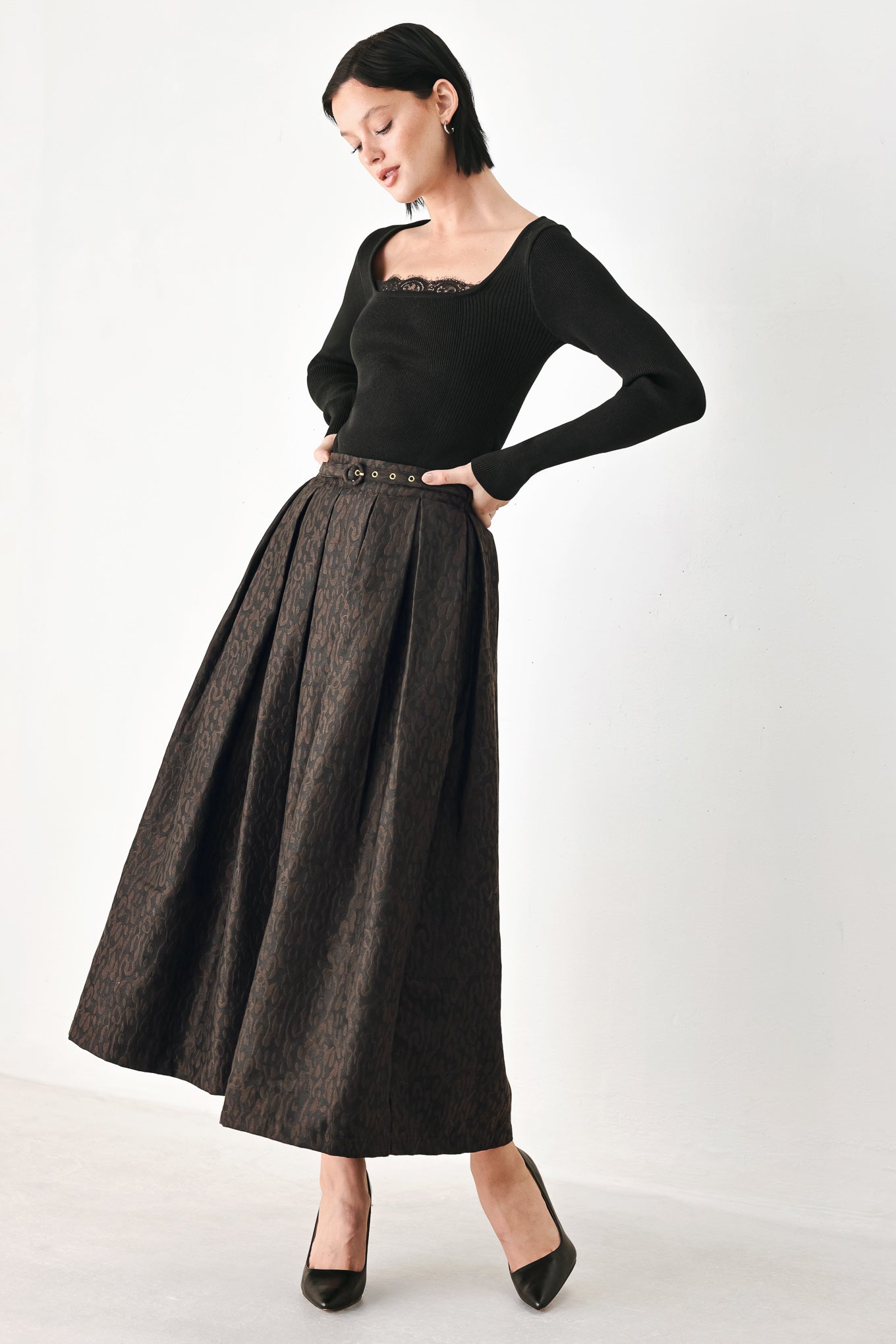 A high-waisted, pleated midi skirt in a dark brown and black jacquard leopard print pattern, styled with a matching belt  | FREEMARKET