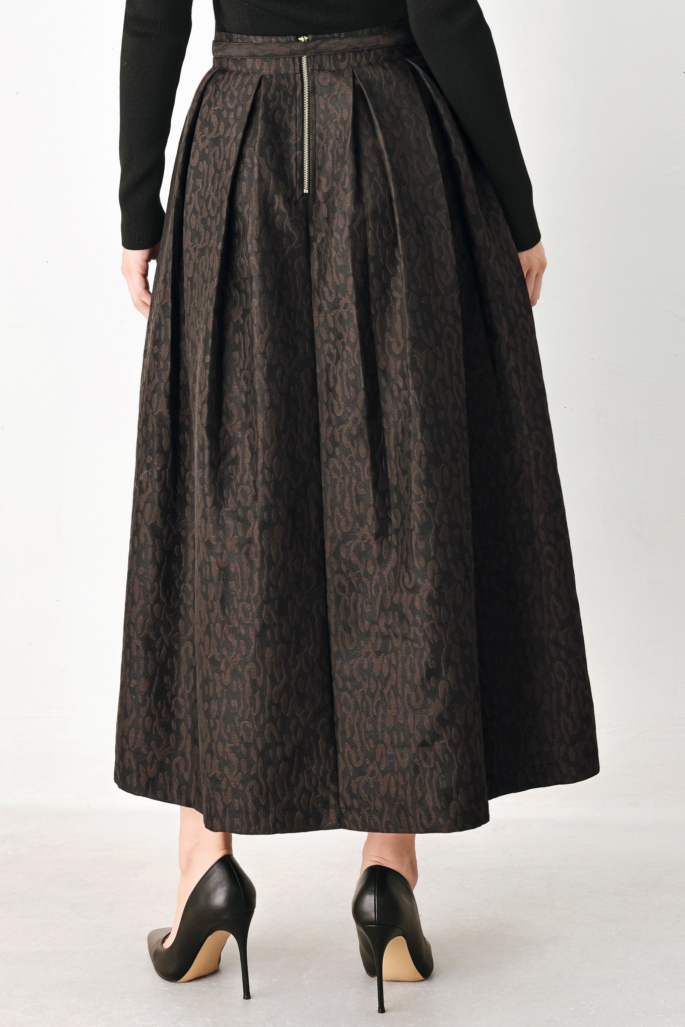 A high-waisted, pleated midi skirt in a dark brown and black jacquard leopard print pattern, styled with a matching belt  | FREEMARKET