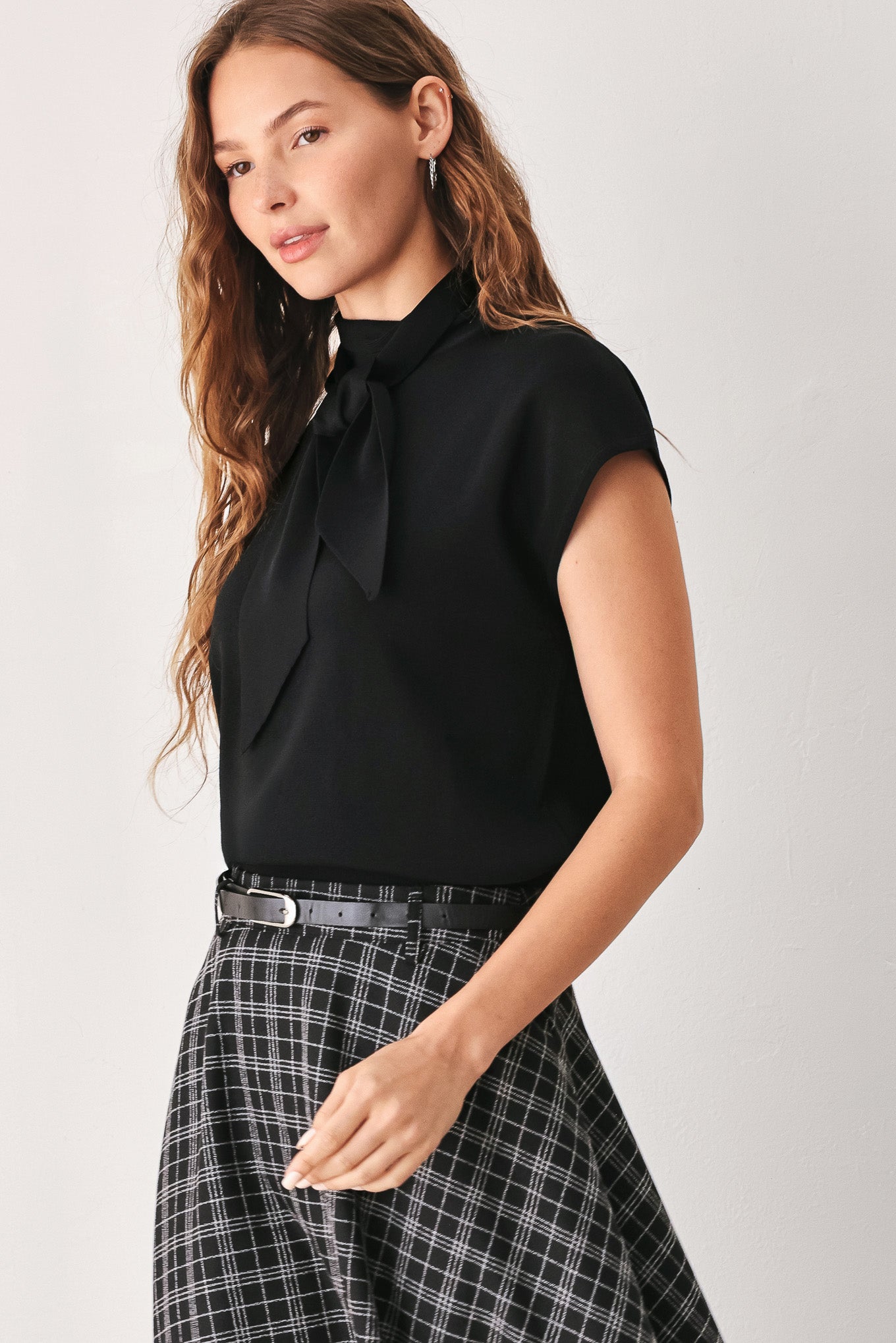 A woman wearing a black and gray plaid midi skirt with a black belt | FREEMARKET