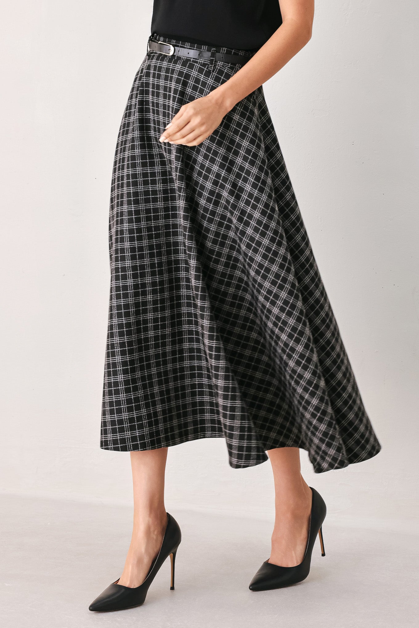 A woman wearing a black and gray plaid midi skirt with a black belt | FREEMARKET