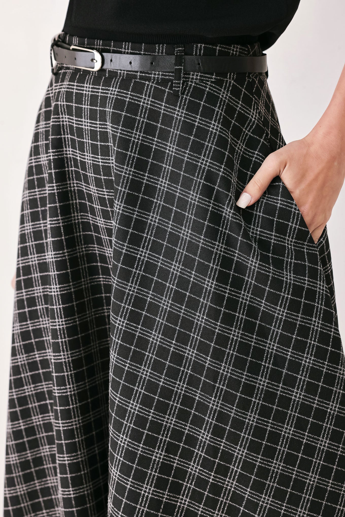 A woman wearing a black and gray plaid midi skirt with a black belt | FREEMARKET