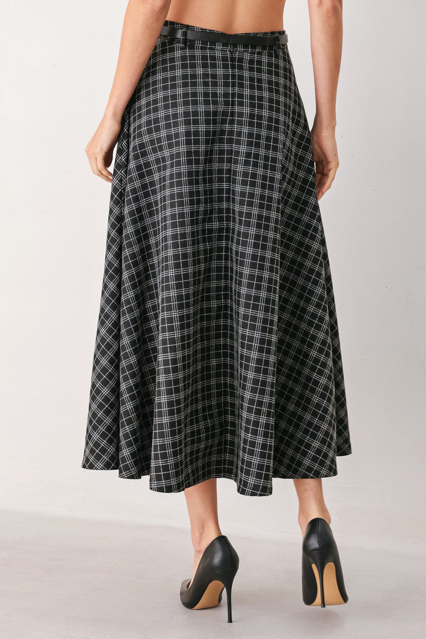 A woman wearing a black and gray plaid midi skirt with a black belt | FREEMARKET