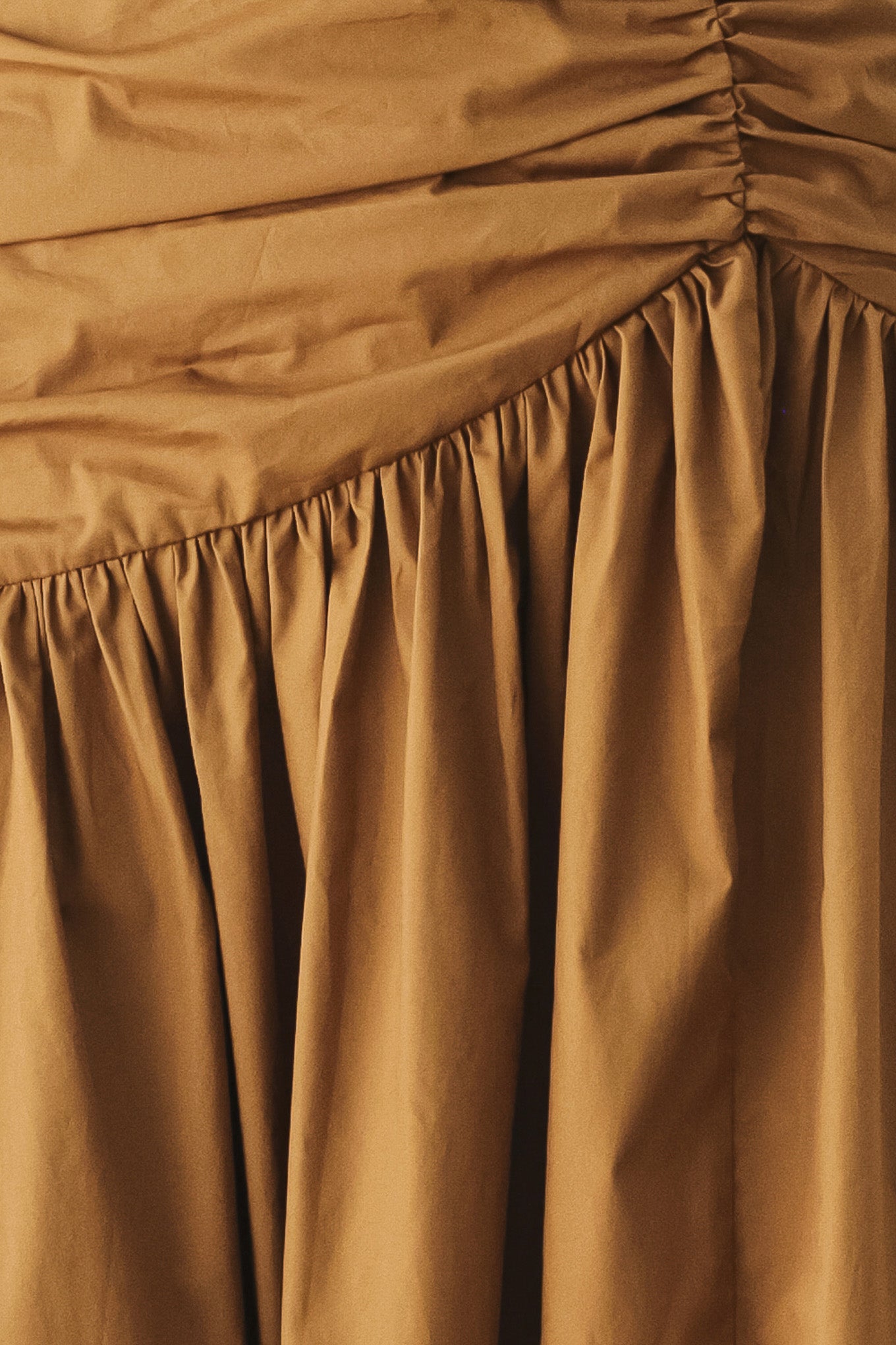 A model wearing a high-waisted, ruched A-line midi skirt in a warm caramel brown color | FREEMARKET