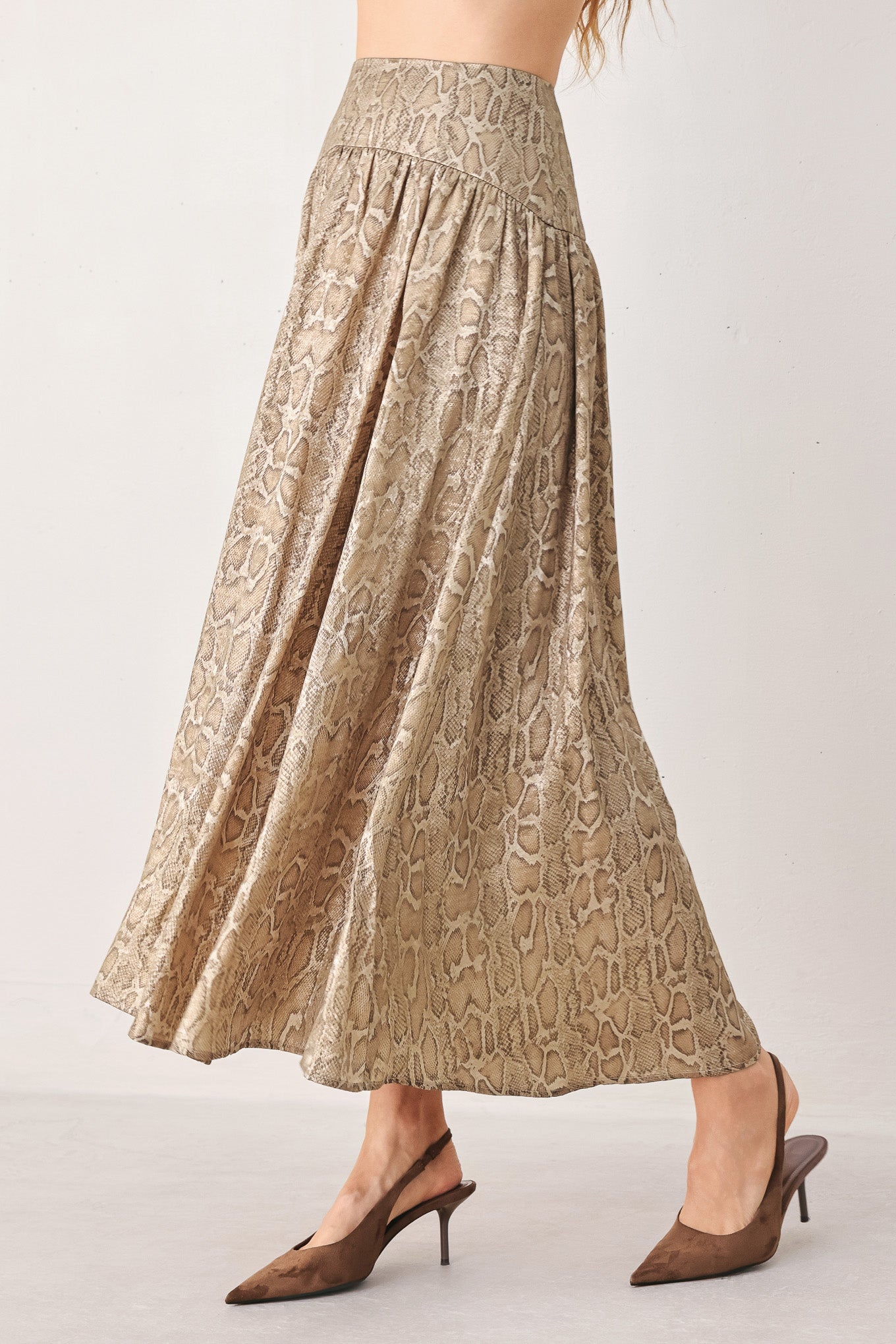 A woman wearing a high-waisted, A-line midi skirt with an all-over beige and brown snakeskin pattern | FREEMARKET