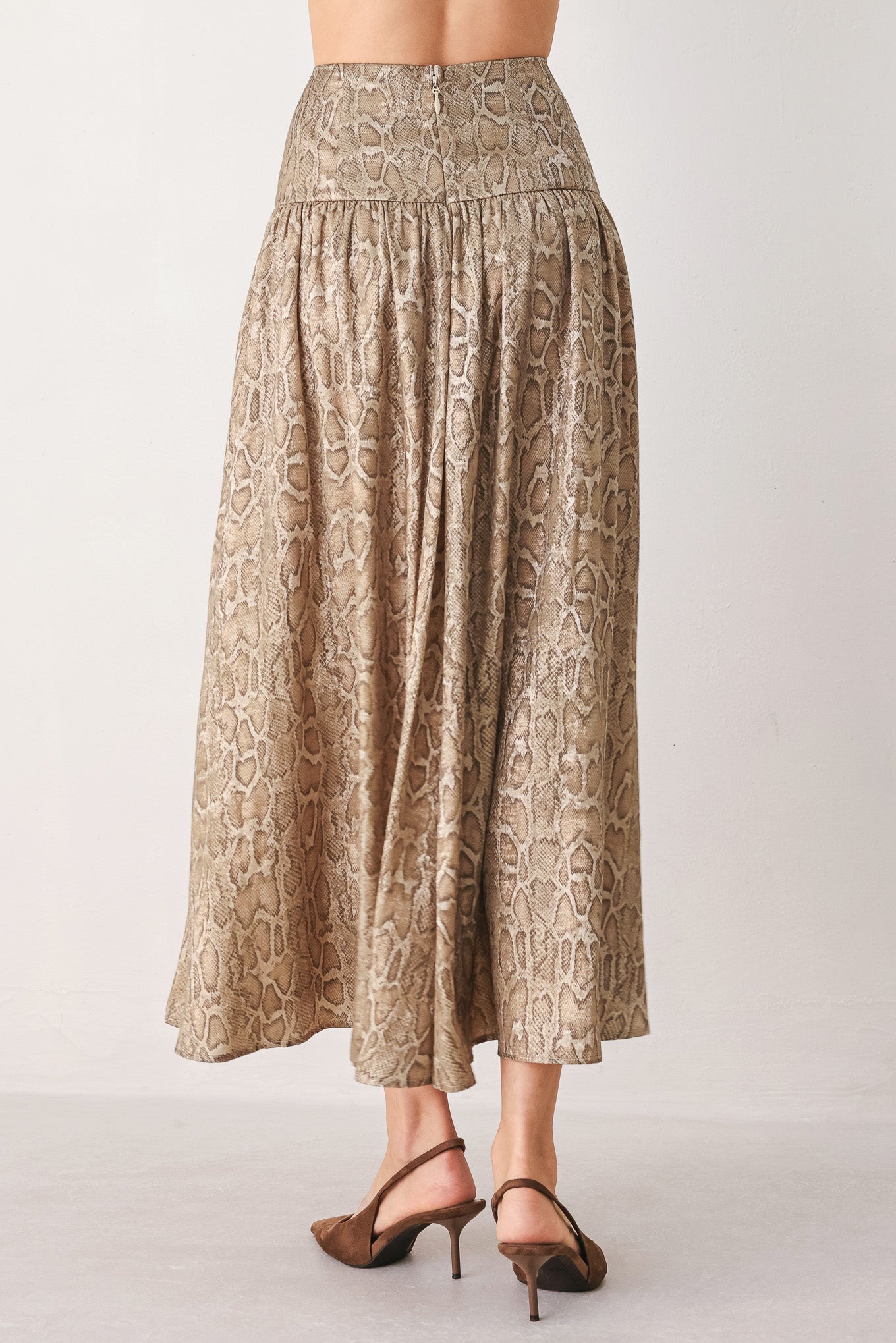 A woman wearing a high-waisted, A-line midi skirt with an all-over beige and brown snakeskin pattern | FREEMARKET