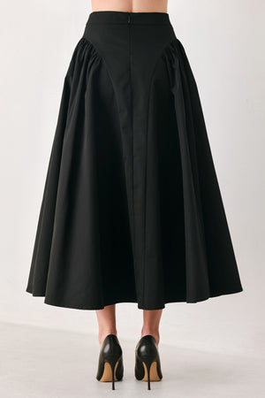 Woman wearing a high waisted black midi skirt with side shirring along the hips | FREEMARKET