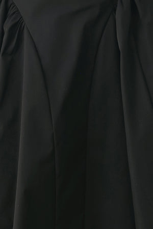 Woman wearing a high waisted black midi skirt with side shirring along the hips | FREEMARKET