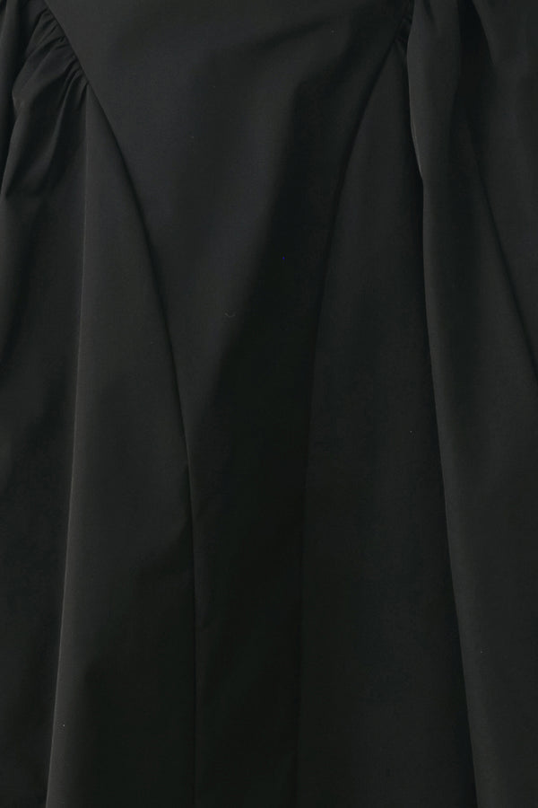 Woman wearing a high waisted black midi skirt with side shirring along the hips | FREEMARKET