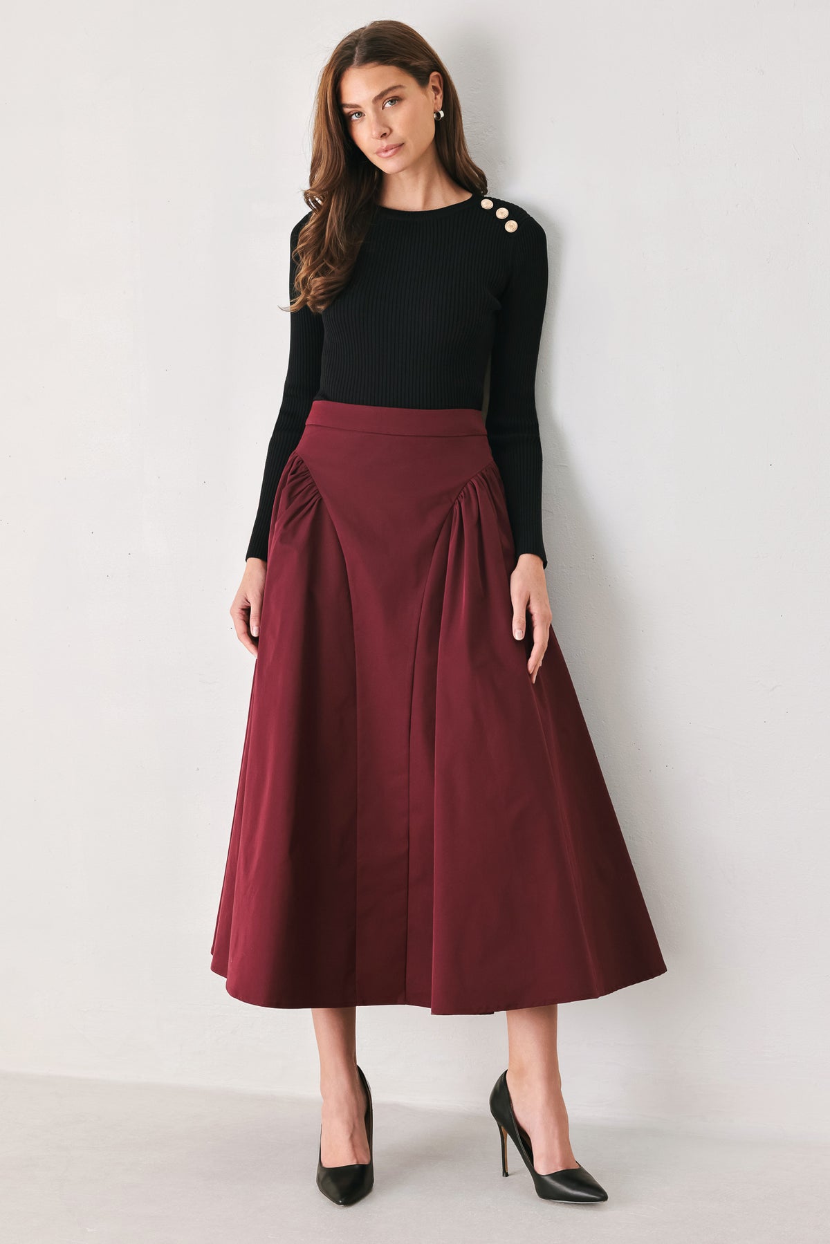 Woman wearing a high waisted burgundy midi skirt with side shirring along the hips | FREEMARKET