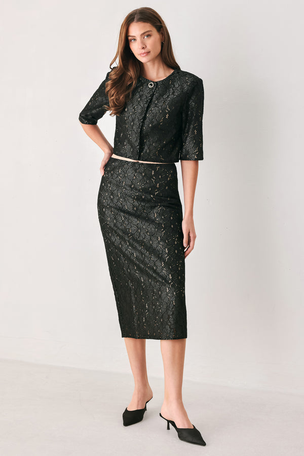 Woman wearing a black lace high waisted midi skirt with a nude base | FREEMARKET