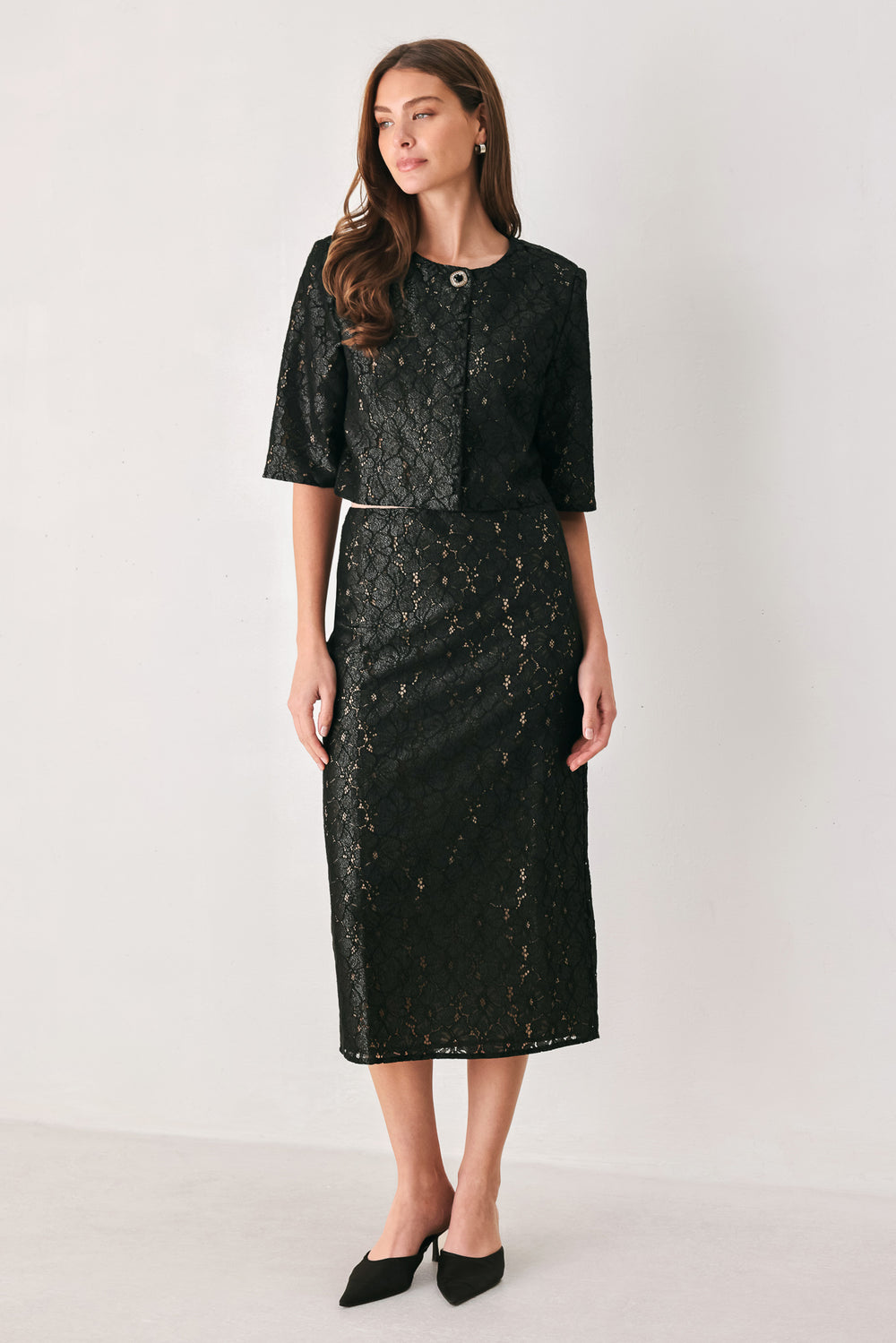 Woman wearing a black lace high waisted midi skirt with a nude base | FREEMARKET