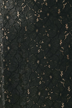Woman wearing a black lace high waisted midi skirt with a nude base | FREEMARKET