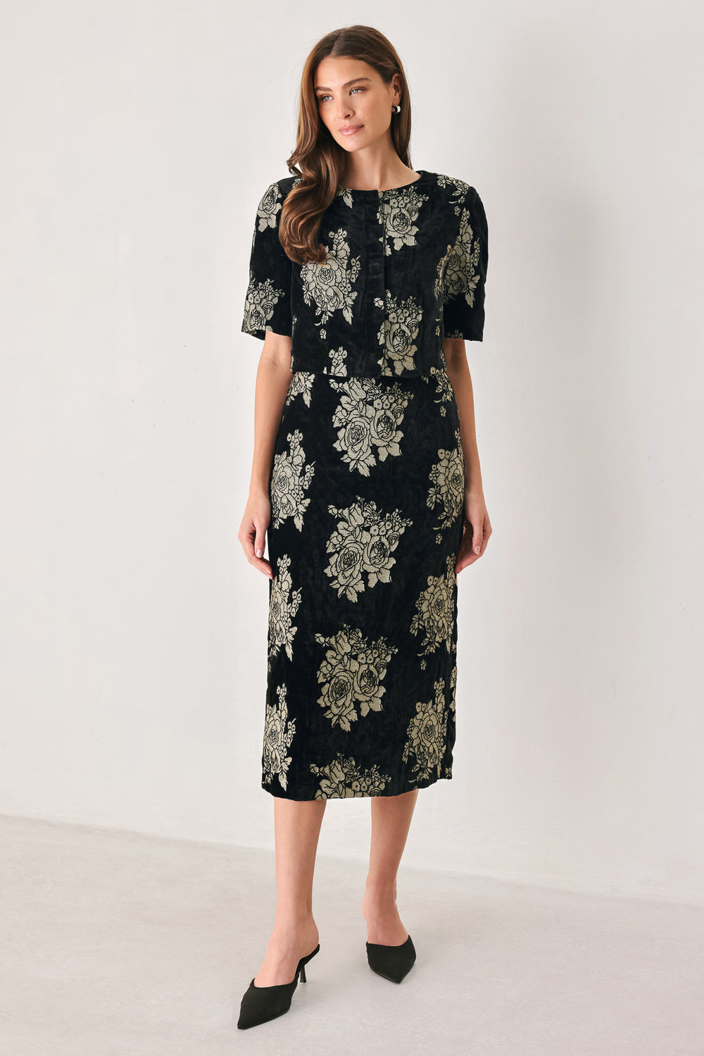 Woman wearing a back high waisted midi skirt with gold jacquard flowers | FREEMARKET