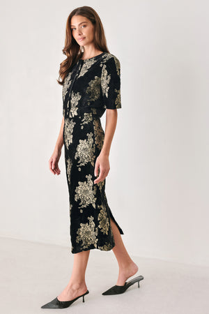 Woman wearing a back high waisted midi skirt with gold jacquard flowers | FREEMARKET