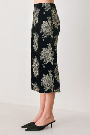 Woman wearing a back high waisted midi skirt with gold jacquard flowers | FREEMARKET