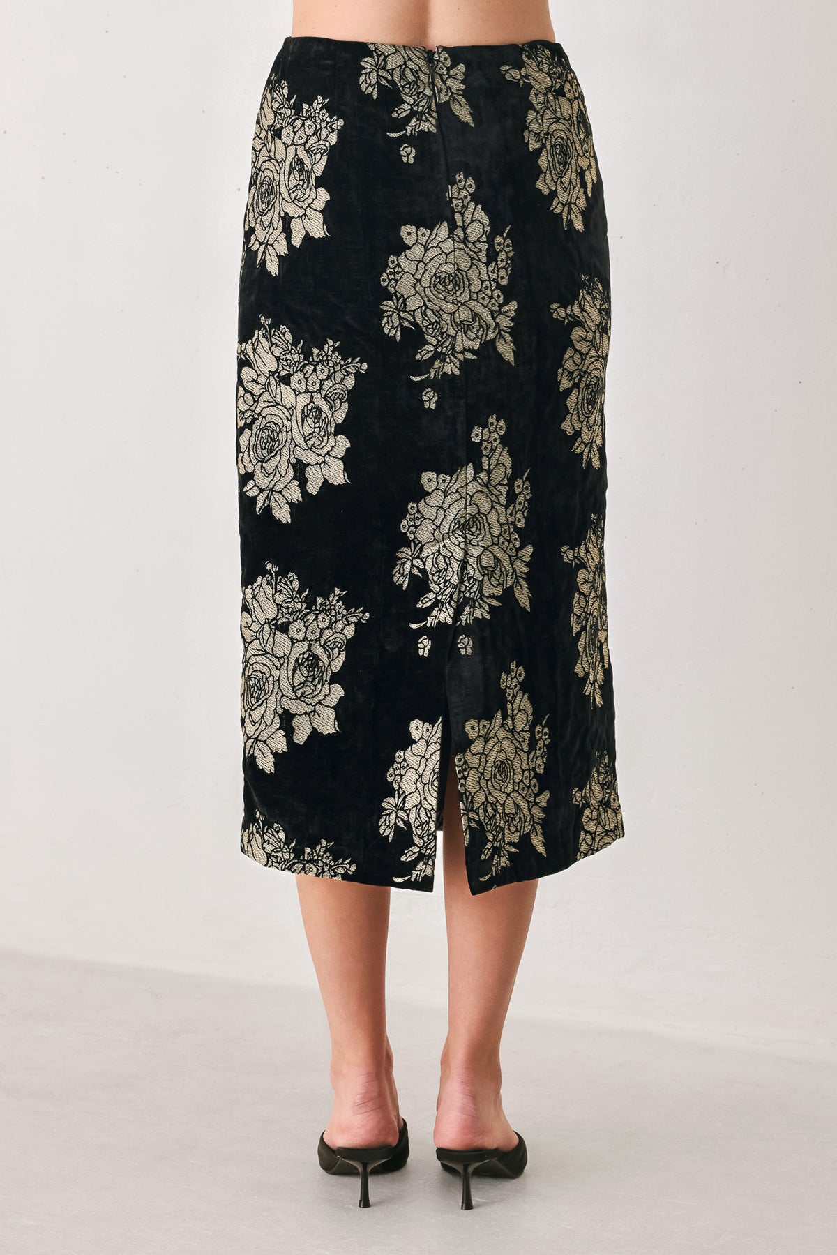 Woman wearing a back high waisted midi skirt with gold jacquard flowers | FREEMARKET