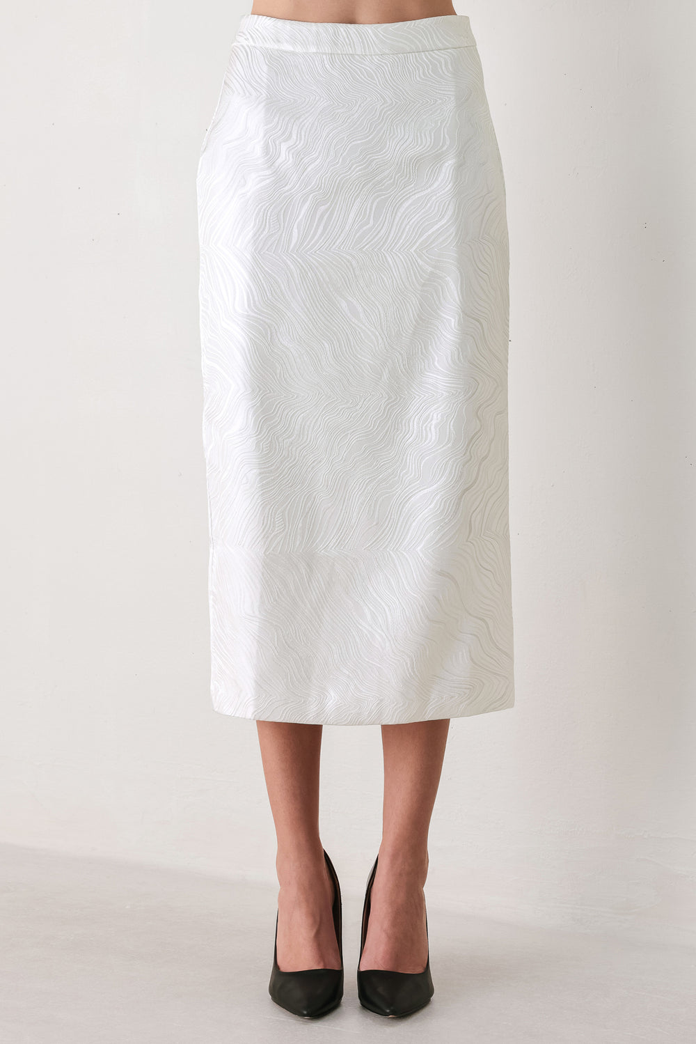 A white midi skirt with a subtle textured, wavy jacquard pattern, shown on a model | FREEMARKET