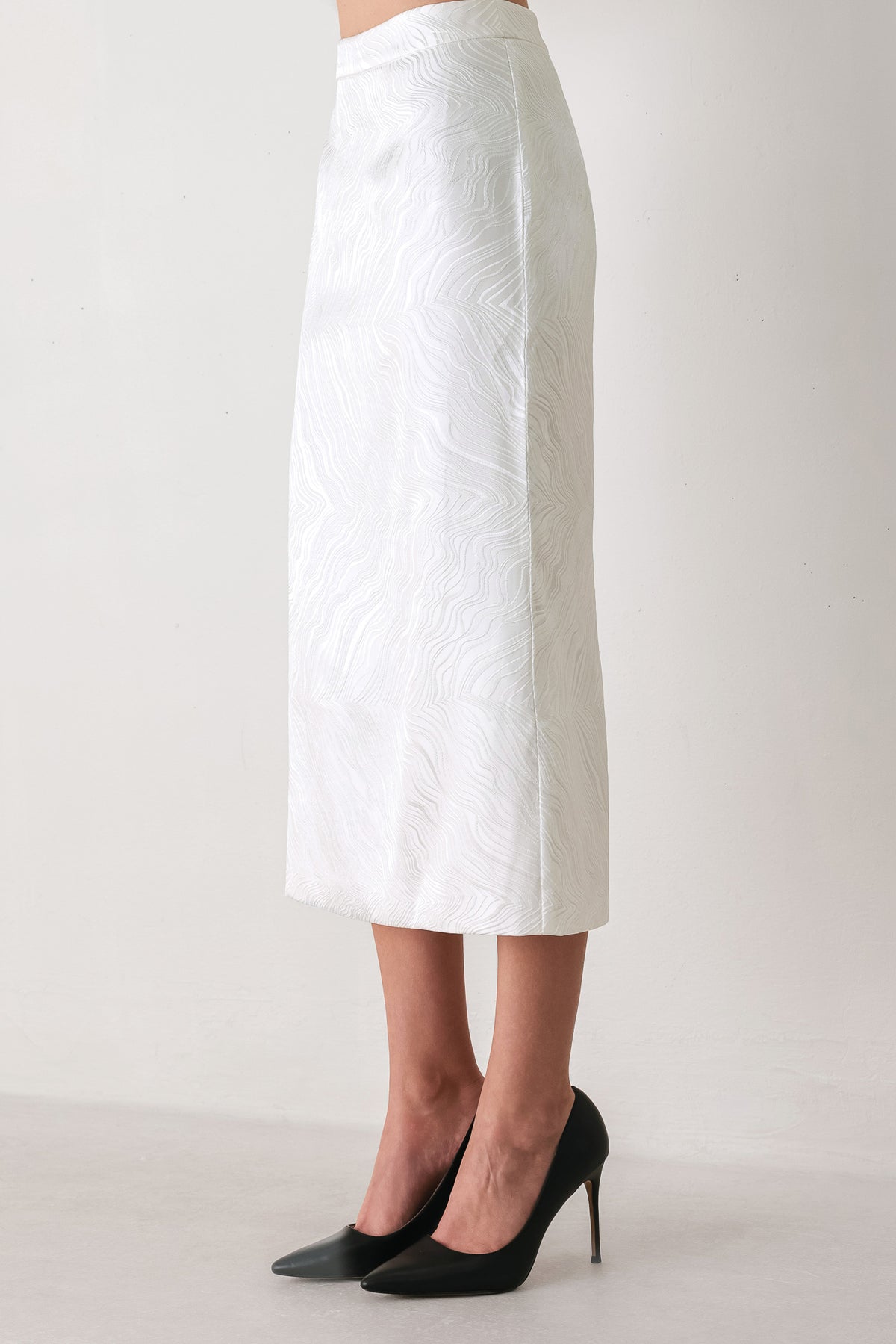 A white midi skirt with a subtle textured, wavy jacquard pattern, shown on a model | FREEMARKET