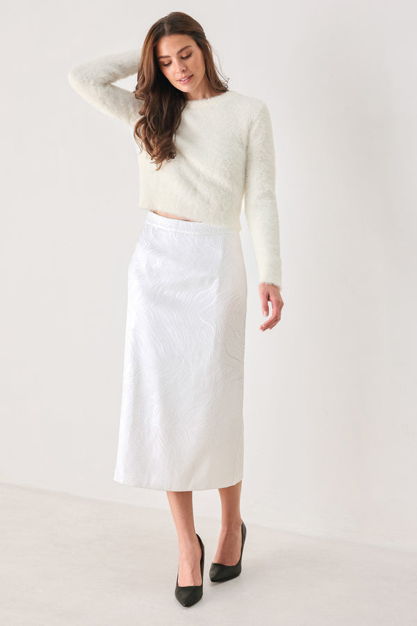 A white midi skirt with a subtle textured, wavy jacquard pattern, shown on a model | FREEMARKET
