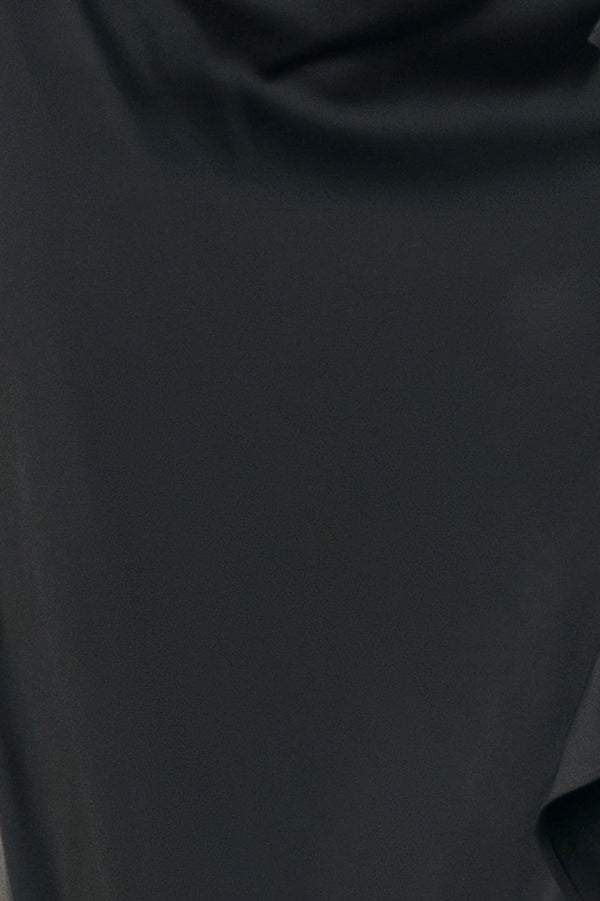 A black midi skirt with a draped, gathered waist and cascading ruffle detail along the side, shown on a model | FREEMARKET