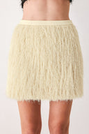 A close-up of a model wearing a cream-colored, shaggy, textured mini skirt | FREEMARKET