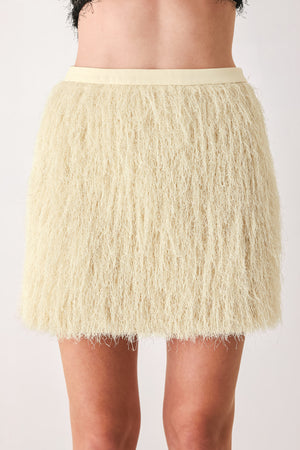 A close-up of a model wearing a cream-colored, shaggy, textured mini skirt | FREEMARKET
